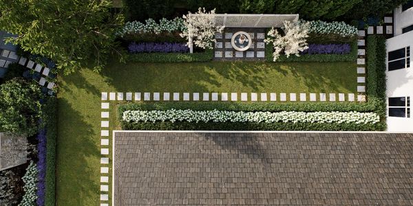 Aerial view of a neatly landscaped garden with stone paths and flowering plants.