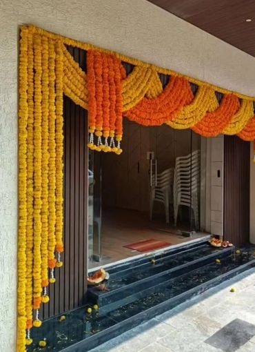 Entrance decorated with orange and yellow marigold flower garlands.