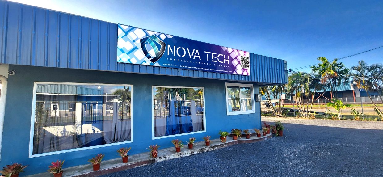 Blue Nova Tech building with large windows and potted plants outside.