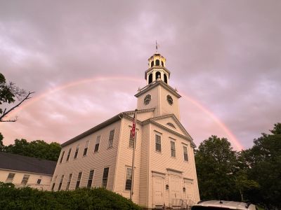 Church building with a rainbow overhead.