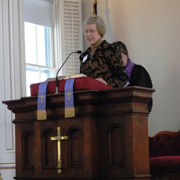 A woman speaking at a church pulpit.