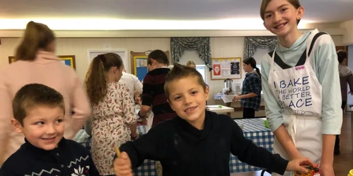 Kids smiling and enjoying a group activity indoors.