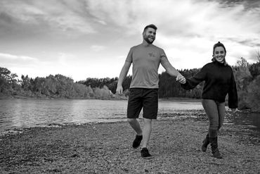 Engaged couple holds hands smiling from ear to ear