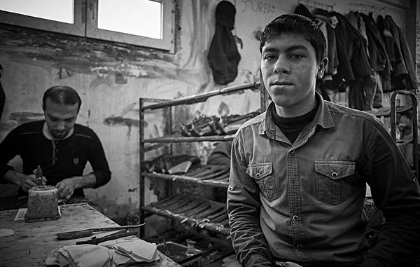 Black and white photograph of two men in istanbul making shoes.