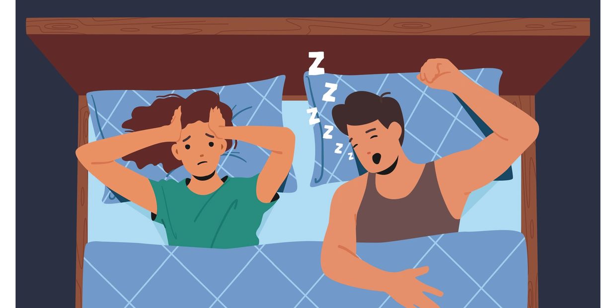 Man snoring while woman looks frustrated in bed.