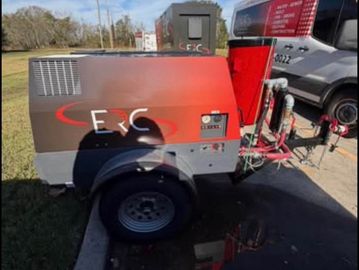 Mobile industrial generator unit parked outdoors near a van.