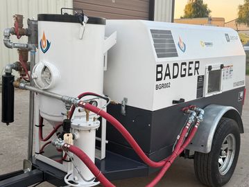 Industrial Badger BGR002 machine with hoses attached, parked outdoors.