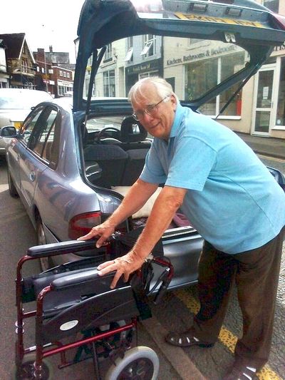Volunteer helping put wheelchair in car boot