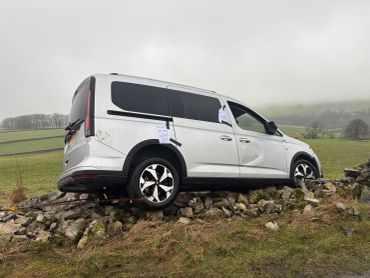 White van stuck on rocks with recovery notes.