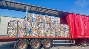 Large bales of compressed recyclable materials loaded on a truck trailer.