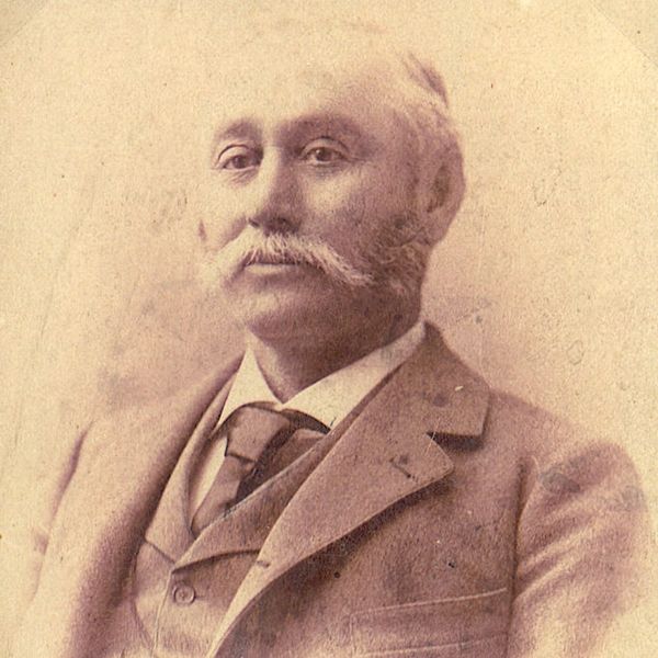 Portrait of an older man with a mustache in vintage attire.