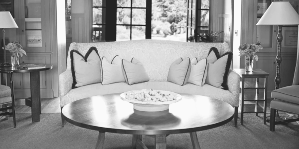 Elegant living room with a sofa, round table, and large windows.