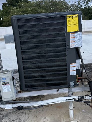 Rooftop HVAC units under cloudy sky with visible energy guide label.