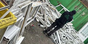 Reframe recycling operative collecting uPVC window frames from trade site in Bootle, Liverpool