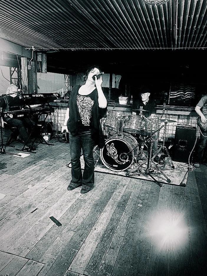 Black and white photo of a band performing indoors.