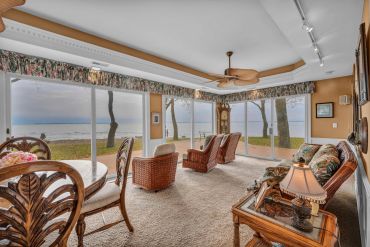 Cozy living room with lake view and wicker furniture.
