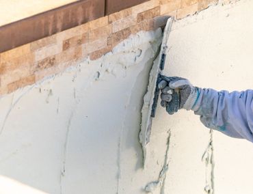 Worker applying plaster on a wall with a trowel.