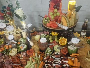A lavish grazing table spread with fruits, cheeses, vegetables, and dips.