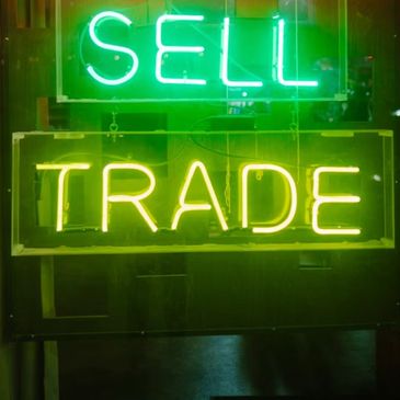 A sign showing this company buys used luxury watches & trades pre-owned luxury watches for upgrades