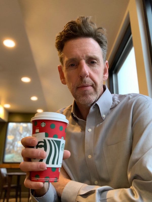 Bob Roark holding a Starbucks coffee cup