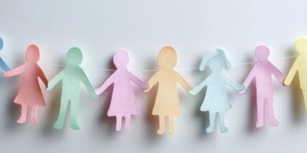 Colorful paper cutouts of children holding hands in a chain.