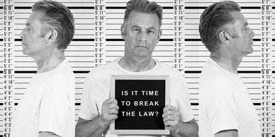Mugshot of a man holding a sign questioning the law.