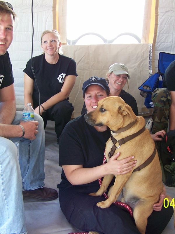 Group of people with a dog indoors.