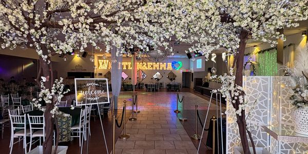 Elegant wedding venue with floral decorations and a welcome sign.