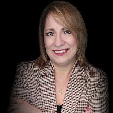 Smiling woman in a checkered blazer against a black background.