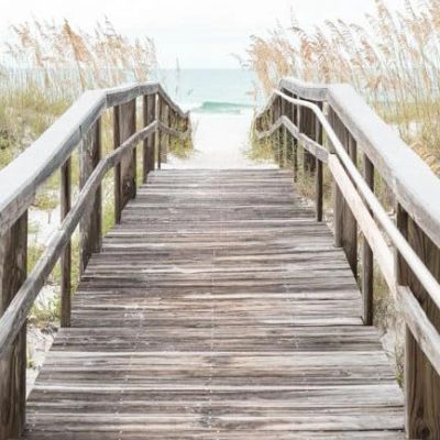 Wooden pathway leading to the beach with sea oats.
