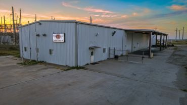 Industrial building at sunset with a sign on the wall.