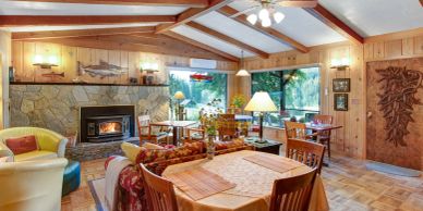 Cozy dining area with wooden walls and fireplace.