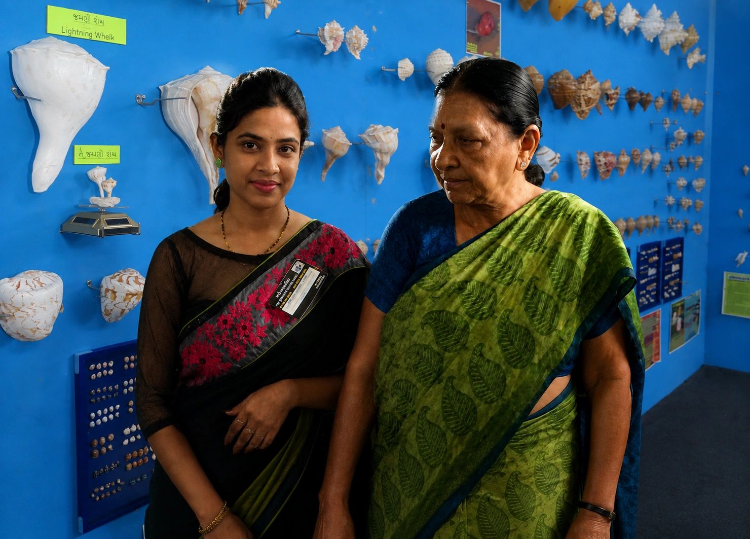 Two women standing in front of a shell display.