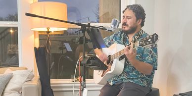 Man playing guitar and singing indoors.