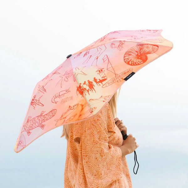 Person holding a red illustrated umbrella.