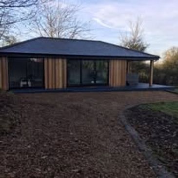 Modern one-story house with wood paneling and large windows.