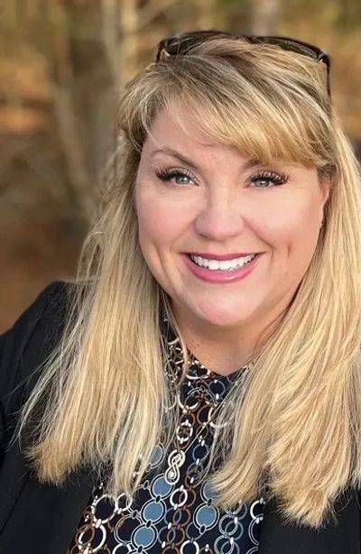 Smiling woman with blonde hair outdoors.
