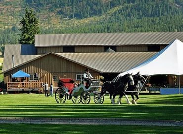 Horse-drawn carriage in front of barn and event tent at Stillwater Ranch.