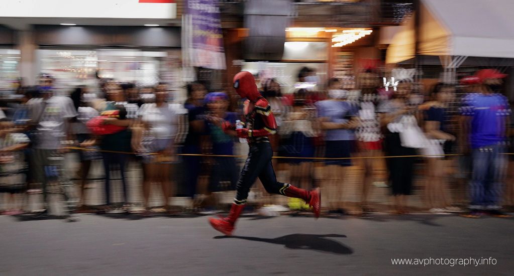 "Late spidey"

This spiderman mascot appears to be late for work.  He's even having a bottle of wate