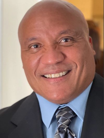 Smiling man in suit and tie.