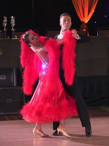 Sabina Zaychikov in a red dress with feathers dancing with her partner Michael Levenkov
