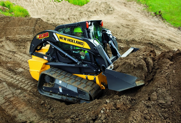New Holland skid steer loader moving soil at a construction site.