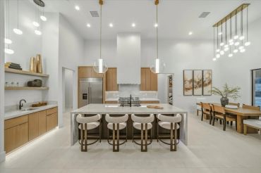 Modern kitchen with porcelain island and designer lighting.