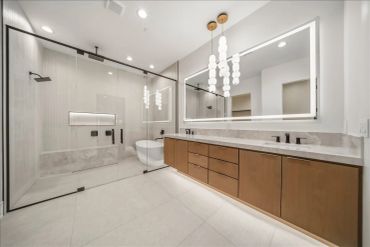 Modern bathroom with glass shower and custom vanity.