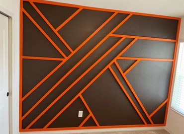 Wall with brown paint and orange geometric trim design.