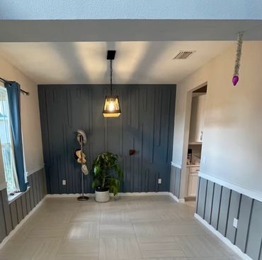 Modern dining room with textured navy accent wall and pendant light.
