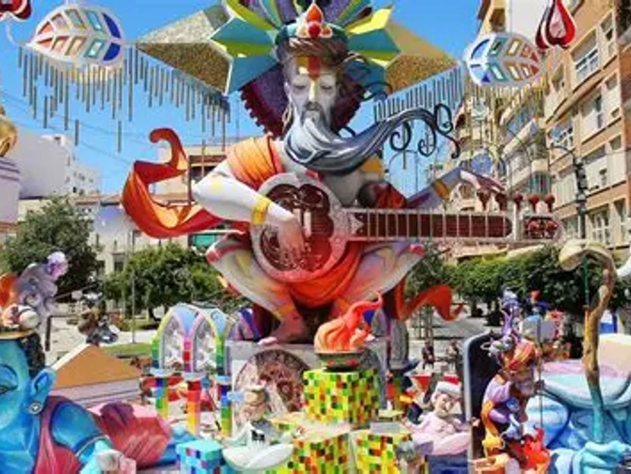 Colorful festival sculpture of a bearded figure playing a stringed instrument outdoors.