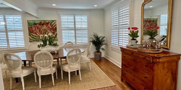 Bright dining room with wooden furniture and floral decor.