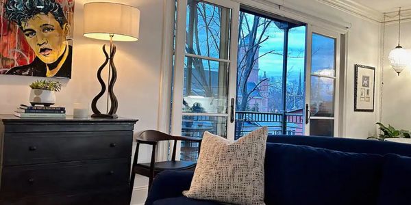 Cozy living room with blue couch and large windows.