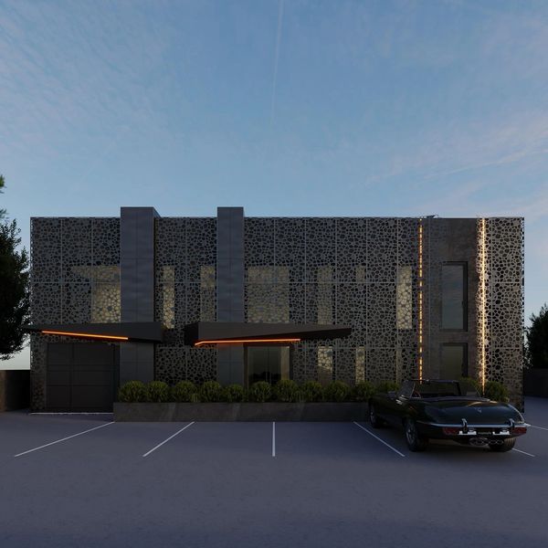 Modern building with intricate facade and vintage car parked outside at dusk.